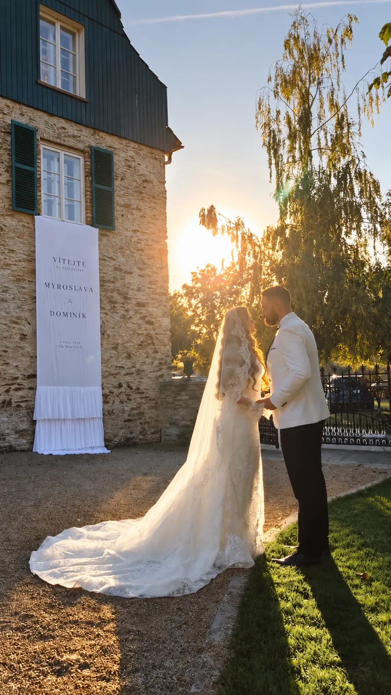 Myroslava a Dominik při západu slunce vedle svatebního banneru